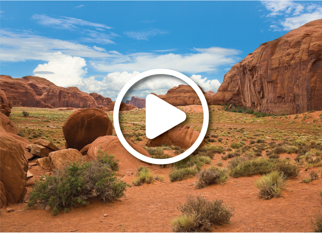 The Monument Valley in UtahArizona state with the red earth desert and rock in the background that looks like a sleeping dragon - The valley is considered sacred by the Navajo Nation - USA.
