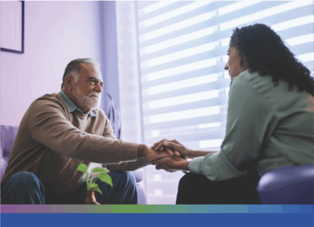 Patient has their hand embraced by a caretaker. It seems like a safe and gentle space to be in.