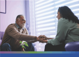 Patient has their hand embraced by a caretaker. It seems like a safe and gentle space to be in.