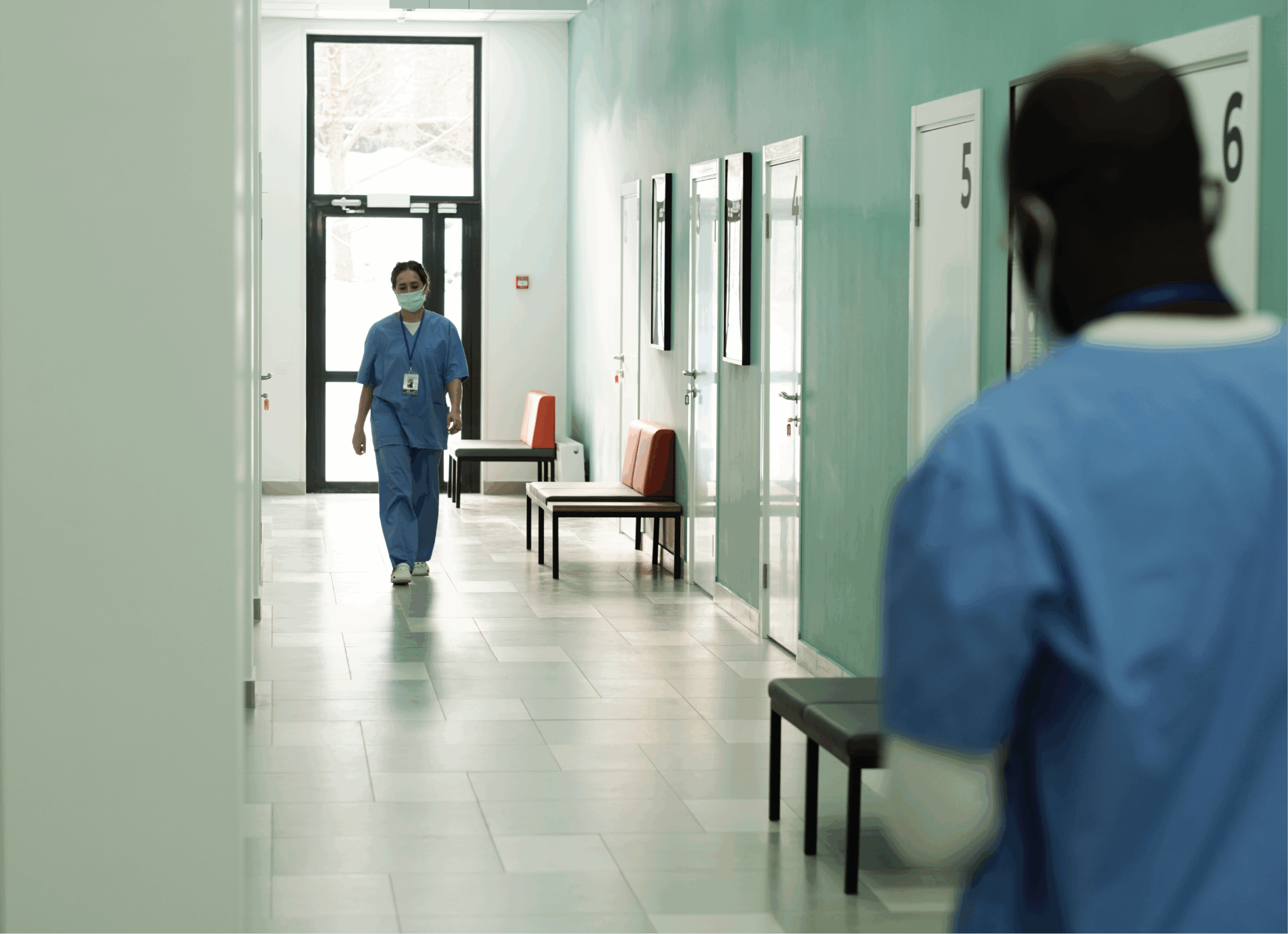 Two nurses walking in correctional facility.