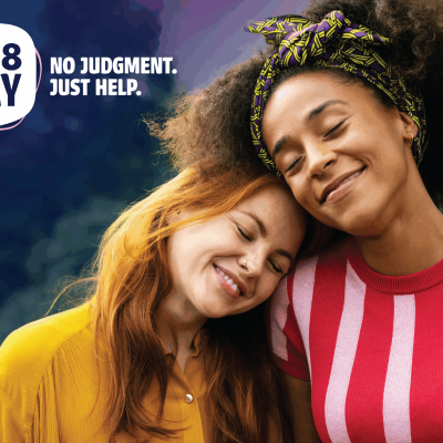 6341-news_posting-ft-image Two wmen lovingly embrace and comfort each other. Head resting on the other's shoulder. Text reads 988 Day, no judgement, no fear.